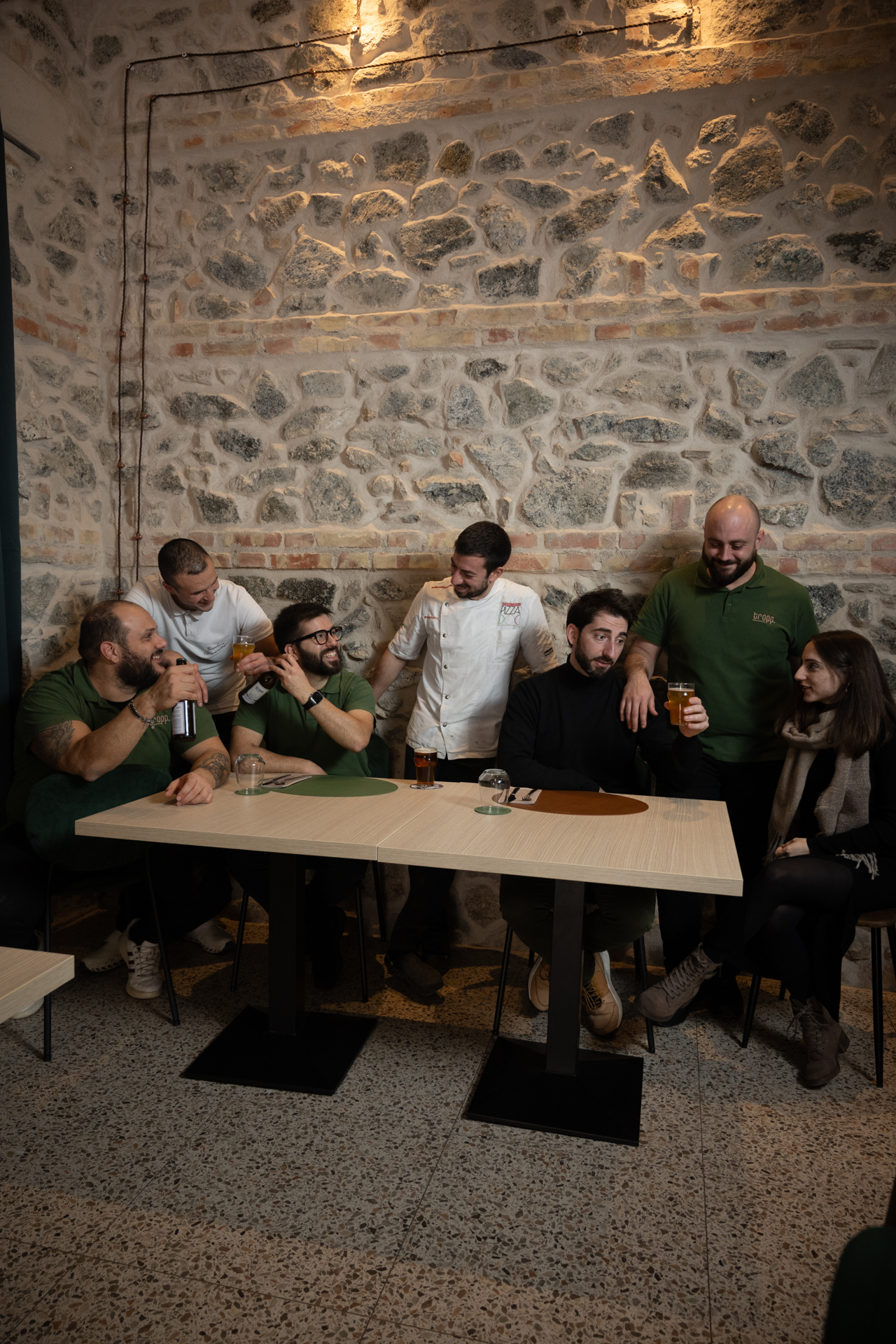 La squadra di Tropp seduta attorno a un tavolo nel locale, fotografia di Tropp